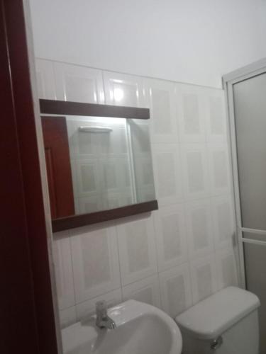 a bathroom with a sink and a toilet and a mirror at Hotel Villa Sol in Oiba