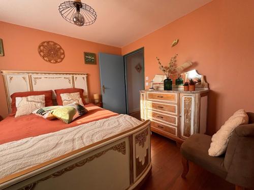 a bedroom with a bed and a dresser at Le Refuge des Vignes in Sainte-Colombe