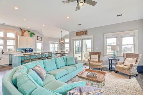 a living room with a blue couch and a kitchen at 4059 - Bikinis Martinis in Kitty Hawk