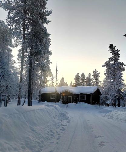 a house covered in snow with a snow covered driveway at Aurora Grande in Saariselka