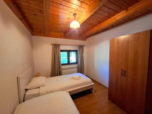 a bedroom with two beds and a wooden ceiling at Zelena Dolina in Ćuić Brdo