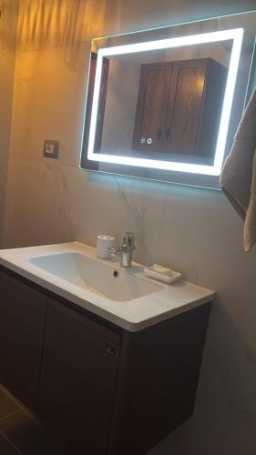 a bathroom with a sink with a light above it at Blue Eye Nature Escape 