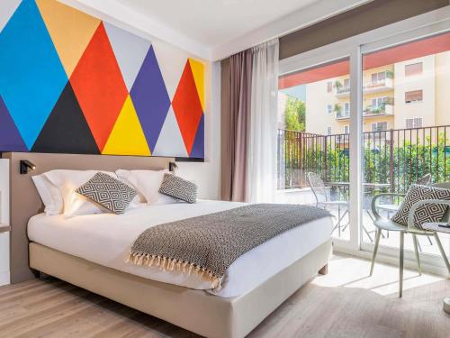 a bedroom with a bed with a colorful painting on the wall at Aparthotel Adagio Rome Vatican in Rome