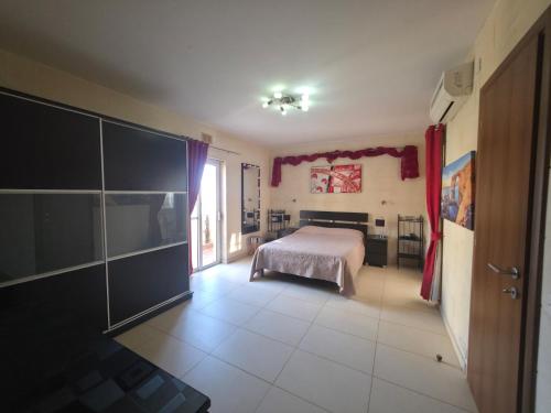 a bedroom with a bed and a large window at Il Bejta penthouse in Qala