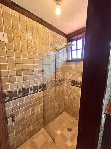 a bathroom with a shower with a glass door at Numa Boa HOSTEL Búzios in Búzios