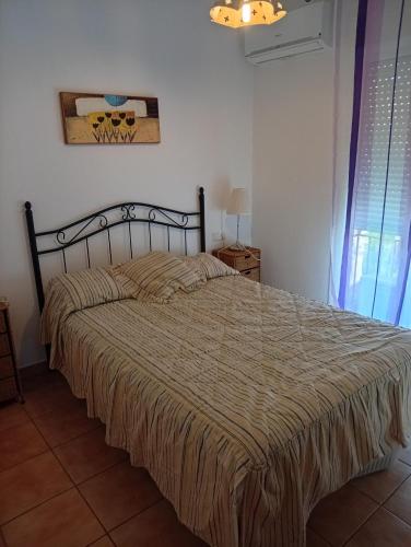 a bedroom with a large bed with a brown comforter at Residencial Golf Playa IV in Islantilla