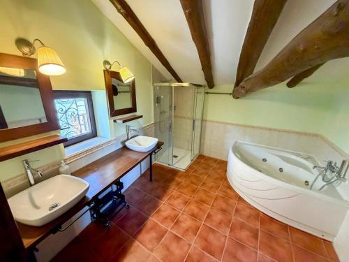a bathroom with a large tub and a sink at Casona del Tajuña in Armuña de Tajuña