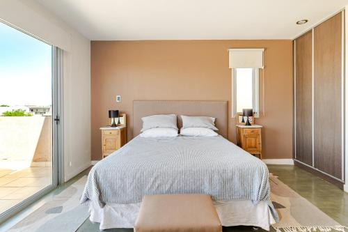 a bedroom with a bed and a large window at Casa Laderas de Chacras de Coria in Chacras de Coria