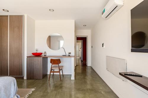a room with a bed and a kitchen with a chair at Casa Laderas de Chacras de Coria in Chacras de Coria