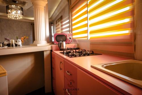 a kitchen with a stove and a sink at Hotel Résidence La Falaise in Douala
