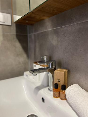 a bathroom sink with a faucet and two bottles at Casa Kollari in Ulcinj