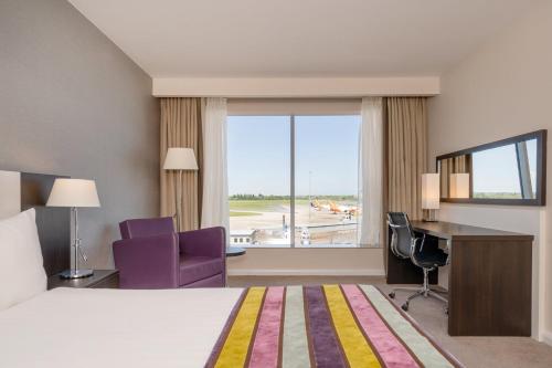 a hotel room with a bed and a desk and a window at Holiday Inn Southend by IHG in Southend-on-Sea