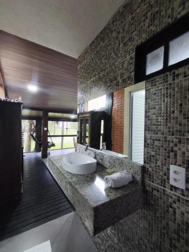 a bathroom with two sinks and a large mirror at Pousada Aquarela de Bombinhas in Bombinhas
