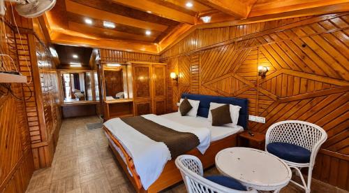 a bedroom with a bed and a table and chairs at Naini Hill View Boho in Nainital