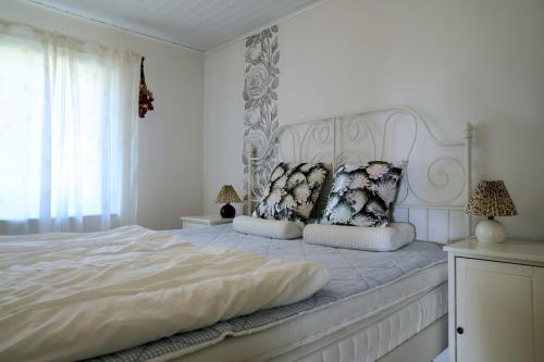 a white bedroom with a large white bed with pillows at Villa near Åhus in Yngsjö