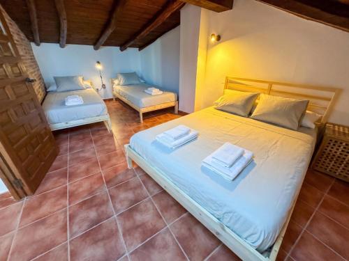 a bedroom with two beds with towels on them at Casona del Tajuña in Armuña de Tajuña
