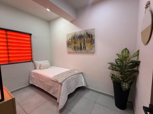a bedroom with a bed and a painting on the wall at Departamento San Lorenzo #102 in Mazatlán