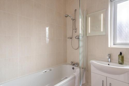 a bathroom with a tub and a sink and a shower at 4 Bed in Amble oc-gd1868 in Amble