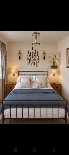 a bedroom with a large bed with a blue blanket at The Mews, Talley in Llandeilo