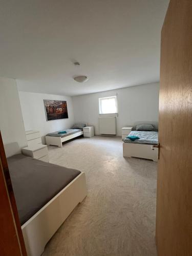 a large room with two beds and a window at Ruhig gelegene Ferienwohnung in Waldbrunn