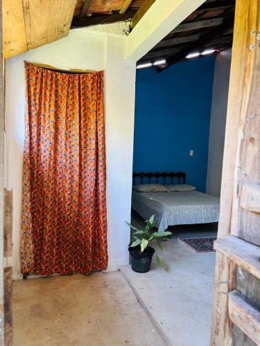 an orange curtain in a room with a bed at Aroeira Suite in Conceição da Barra