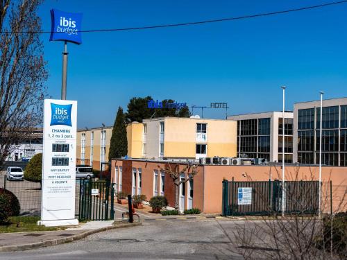 a sign in front of a building with a bus depot at ibis budget Aix en Provence in Aix-en-Provence