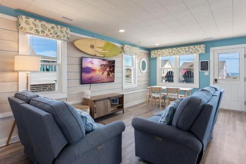 a living room with two blue chairs and a tv at 4119 - The Dolphin Boat in Kitty Hawk