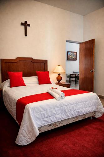 a bedroom with a large bed with a cross on the wall at HOTEL OASIS Matehuala in Matehuala