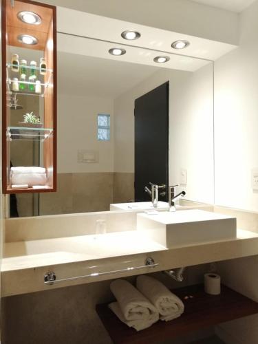 a bathroom with a sink and a large mirror at Pinares Panorama Suites, Spa & Convention Center in Villa Carlos Paz