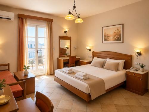 a hotel room with a bed and a table and a desk at Welcome Naxos in Agios Prokopios