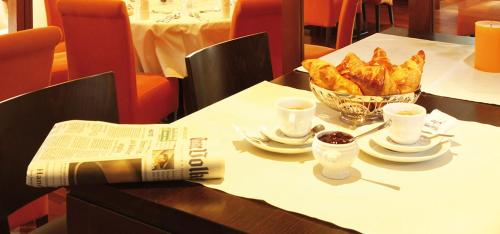 a table with a newspaper and a bowl of food at Landgasthof Zur Post, Hochwälder Radstation in Kell