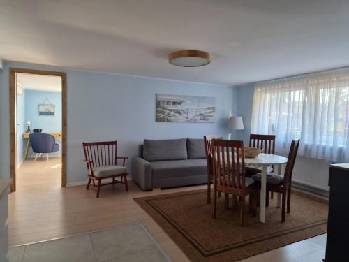 a living room with a couch and a table and chairs at Apartament "Przez las na plażę" in Świnoujście