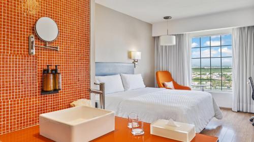 a hotel room with a bed and a desk with a sink at Fiesta Inn Ciudad Juarez in Ciudad Juárez