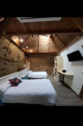 a bedroom with two beds and a desk in it at Hostal La Medina de Camponaraya in Camponaraya