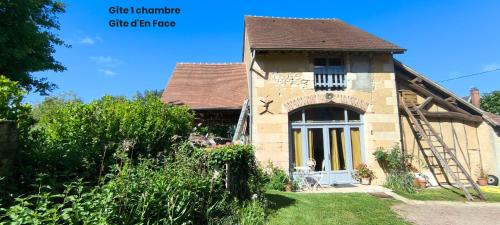 an old stone house with a large window and a porch at La Longère en Puisaye, 2 gîtes à 10 min de Guédelon réservables ensemble et séparément in Dampierre-sous-Bouhy