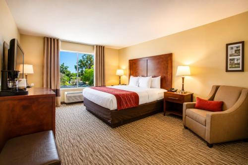 a hotel room with a bed and a chair at Comfort Inn Pomona near Fairplex in Pomona