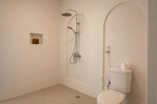 a bathroom with a toilet and a shower at Montelago Batur in Bangli