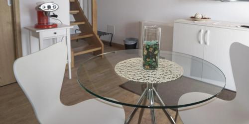 a glass table with a vase on it in a kitchen at B&B Sgonico in Sgonico