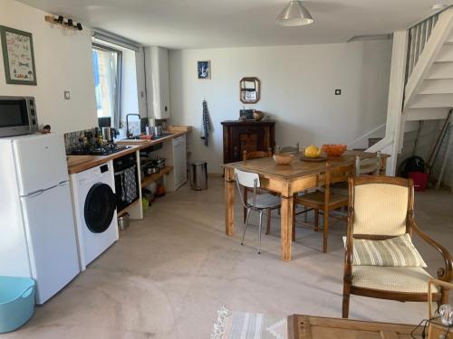 a kitchen with a wooden table and a dining room at Ti Bihan in Plouguerneau