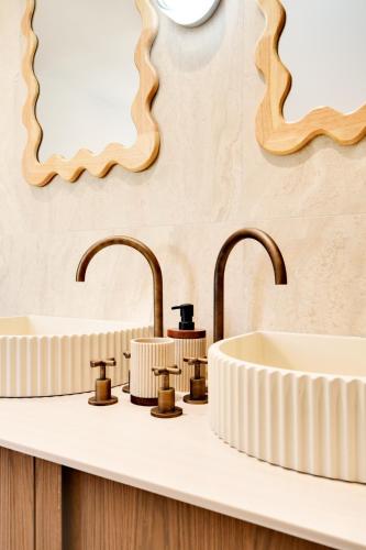 a bathroom with two sinks and two mirrors at Hotel Murmures Notre-Dame in Paris