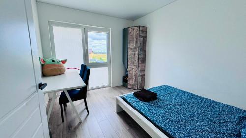 a small room with a bed and a desk and a window at Ungura Nord in Mozūriškiai