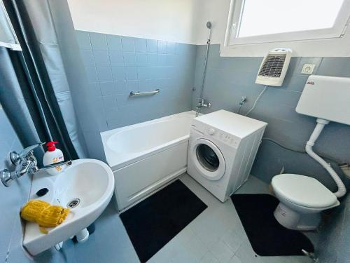 a bathroom with a sink and a washing machine at L&M Apartman in Virje