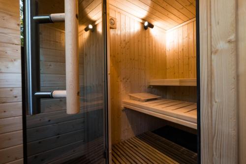 a sauna with wooden walls and a glass door at Wood Chalet Durbuy in Durbuy