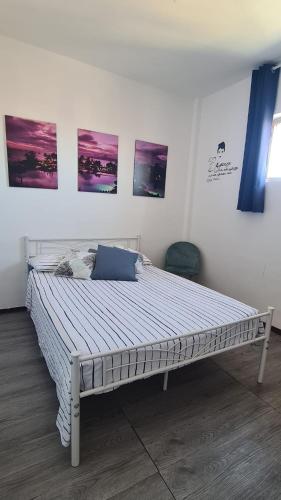 a bed in a room with paintings on the wall at L'angolo di Roby in Termoli