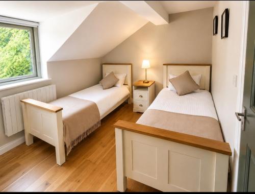 two beds in a room with a window at The Greenmount in Westport