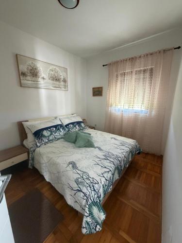 a bedroom with a bed and a window at Apartments Green Oasis in Vlašići
