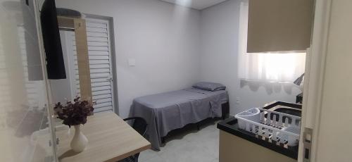 a small bedroom with a bed and a table at Studio 1 in Jundiaí