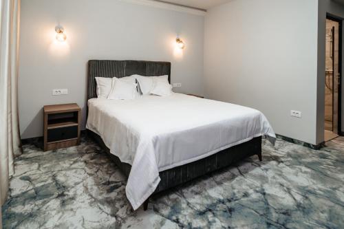 a bedroom with a large bed with white sheets at Airport Hotel - Baia Mare - Maramures in Baia Mare