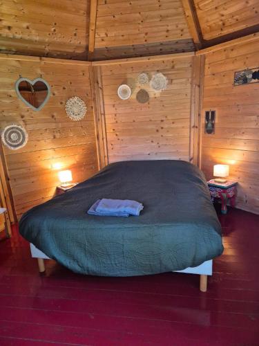 a bedroom with a bed in a room with wooden walls at La Longère du Parc in Noyers-sur-Cher