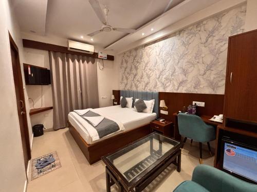 a bedroom with a bed and a desk and a television at Hotel Buddha International in Patna